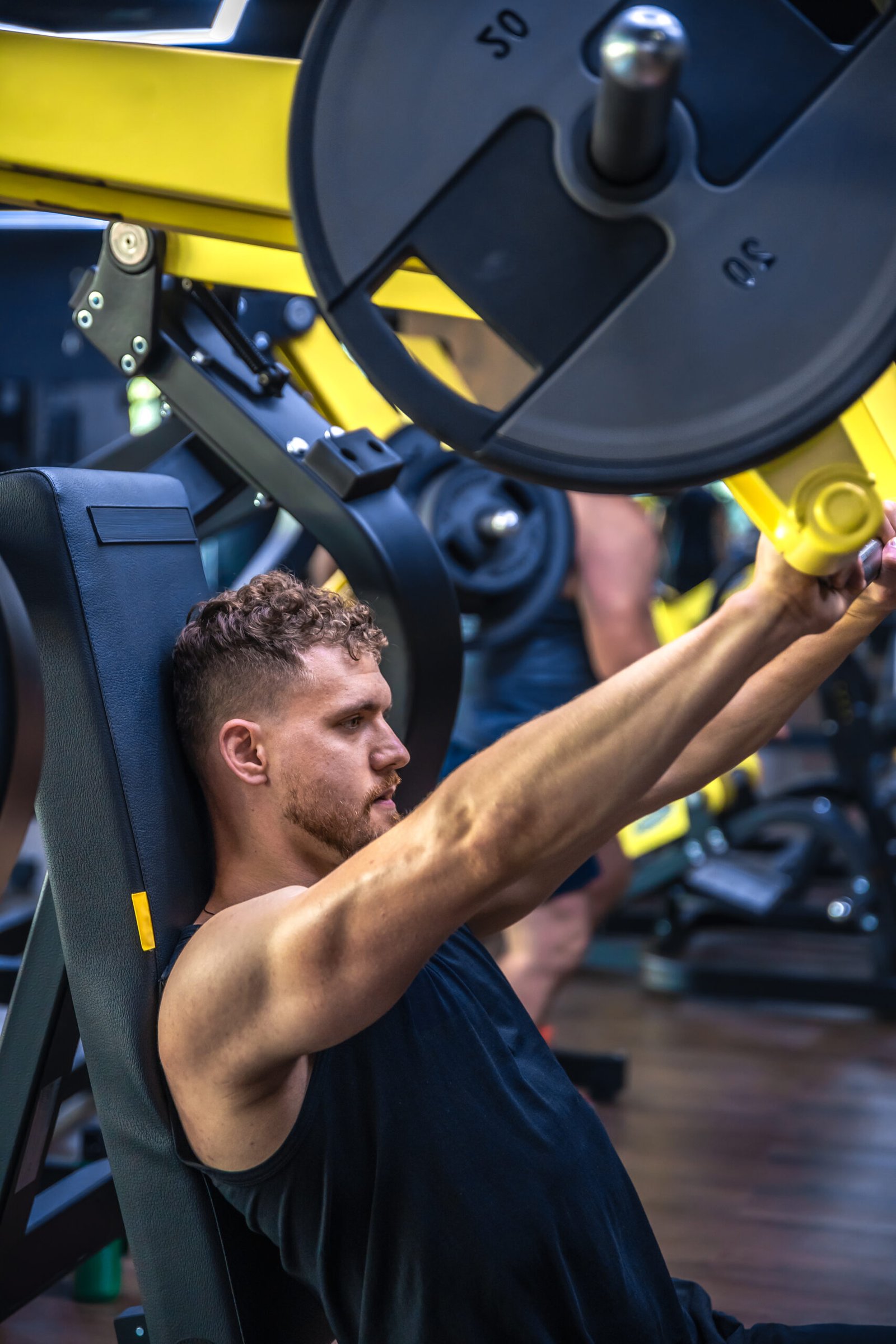 an athlete in the gym swings triceps with a barbell. sports lifestyle.